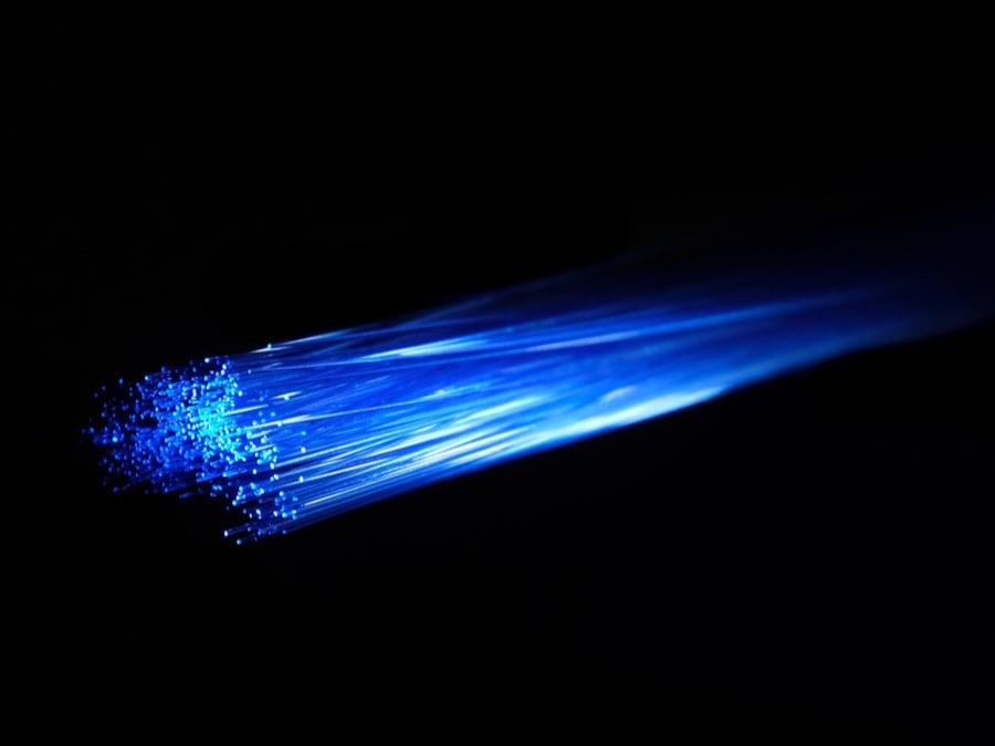 Bundle of blue fibre-optic strands glowing in the dark